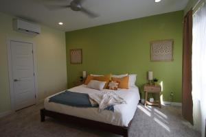 a bedroom with a large bed with green walls at Posh 210 in San Antonio