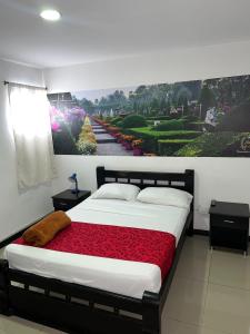 - une chambre avec un lit orné d'une peinture murale dans l'établissement Hotel El Jardín Cafetero Armenia, à Armenia