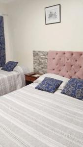 1 dormitorio con 2 camas y almohadas azules en Hostal Donde Gabriel, en Chillán