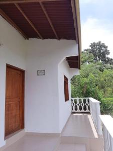 Casa blanca con puerta de madera y porche en Casa Majanicho, en Rincón