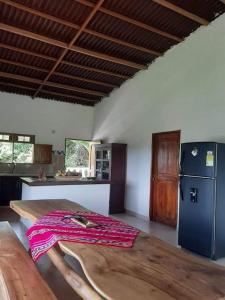 cocina con mesa de madera y nevera en Casa Majanicho, en Rincón
