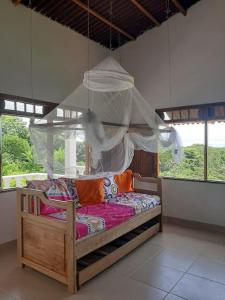 1 dormitorio con 1 cama con dosel y ventanas en Casa Majanicho, en Rincón