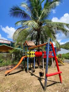 un parque infantil frente a una palmera en Ocean Blue Condos in Jacó, en Puntarenas