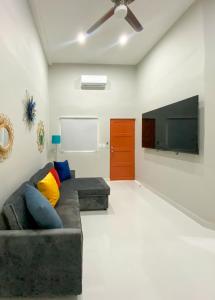 sala de estar con sofá y TV de pantalla plana en Ocean Blue Condos in Jacó, en Puntarenas