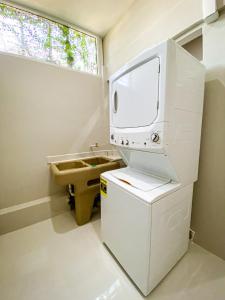 baño con TV y lavabo. en Ocean Blue Condos in Jacó, en Puntarenas