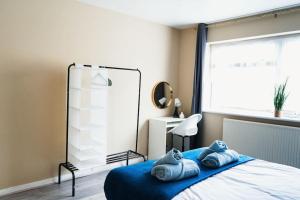 a bedroom with a bed with blue pillows on it at Cosy 2BR Flat - Beach Nearby in Kent
