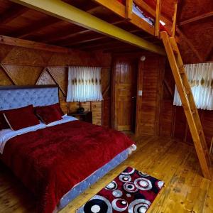 Un dormitorio con una cama roja y una escalera en Playa Blanca Baruch Glamping Tota, en Tota