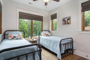 2 camas en una habitación con 2 ventanas en The Kingfisher Pet Friendly, Lakefront Luxury, Private Beach, en Nebo