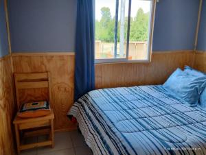 a small bedroom with a bed and a window at Cabaña Precordillera Cunco in Cunco