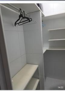 a white closet with a hanger in it at Ótimo Apt de 1qt a 60mts do Consulado EUA in Recife