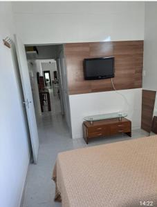 a bedroom with a bed and a tv on a wall at Ótimo Apt de 1qt a 60mts do Consulado EUA in Recife