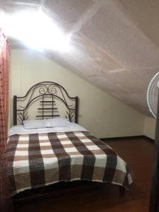 1 dormitorio con 1 cama con manta blanca y negra en Casa de campo Country house in Yunguilla, Cuenca, Ecuador, en Cuenca