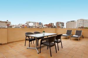 AC Hotel Los Vascos by Marriott في مدريد: طاولة وكراسي على شرفة مطلة