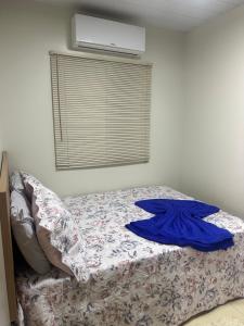 een bed met een blauw shirt erop in een slaapkamer bij Casamoura in Maragogi