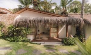 a house with a thatched roof and a patio at Yama Balian in Tabanan