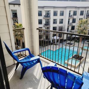 a balcony with two chairs and a swimming pool at Relaxing Pool View Apt Reliant Stadium/Medical Center in Houston