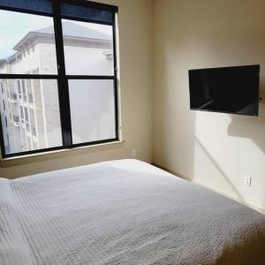 a bedroom with a bed and a large window at Relaxing Pool View Apt Reliant Stadium/Medical Center in Houston