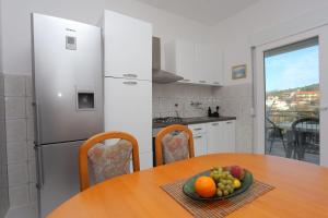 - une cuisine avec une table et un bol de fruits dans l'établissement Apartments with a parking space Marina, Trogir - 1093, à Marina