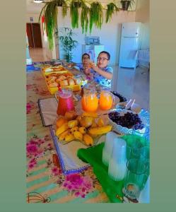 two children sitting at a table with fruit and juice at Pousada residencial in Curvelo