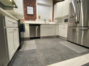a kitchen with white cabinets and stainless steel appliances at Entire 2 Bed apartment in Allentown +10 photos