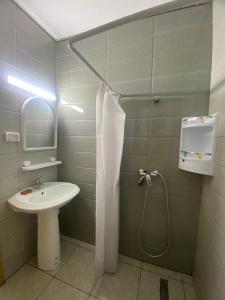 La salle de bains est pourvue d'un lavabo et d'une douche. dans l'établissement Beach houses Lost paradise, à Mouamla