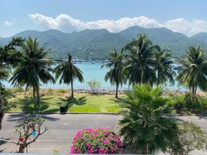 Blick auf einen Strand mit Palmen und Blumen in der Unterkunft M Villa Nha Trang in Nha Trang