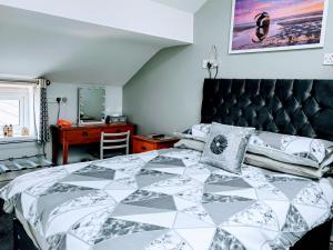 a bedroom with a bed with a black and white comforter at Seahawk Holiday Apartments in Cleveleys