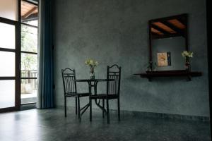 uma mesa de jantar com 2 cadeiras e um espelho em Amanzi Residence em Kandy
