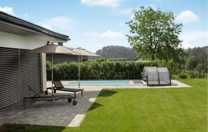 un patio con una silla y una sombrilla junto a la piscina en Villa Mit Pool In Stegersbach, en Neudauberg