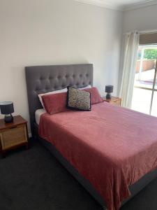 a bedroom with a large bed with red sheets and pillows at Central Yarrawonga in Yarrawonga