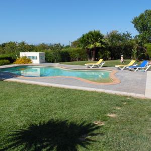 a swimming pool with two lounge chairs next to it at Horta Nova in Lagos