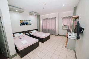 Cette chambre comprend 2 lits et une télévision. dans l'établissement GC Hotel, à Zamboanga