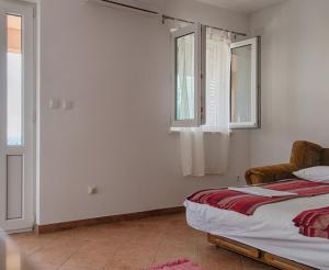 1 dormitorio con cama, ventana y silla en Apartment Sveta Nedilja 14086a, en Jelsa
