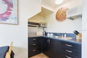 a kitchen with a sink and a microwave at Central CBD in Motueka