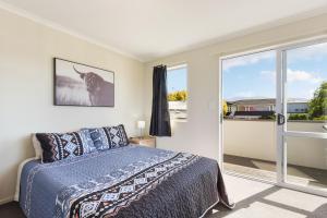 a bedroom with a bed and a large window at Central CBD in Motueka