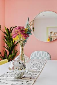 a vase with flowers on a table in front of a mirror at Heated Pool Game Room, Mountain Views in Phoenix