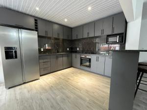 a large kitchen with stainless steel appliances and wooden floors at Casa con piscina climatizada in Ciudad de la Costa