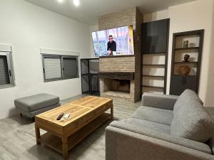 sala de estar con sofá y TV de pantalla plana en Casa con piscina climatizada, en Ciudad de la Costa