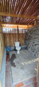 a bathroom with a toilet in a stone wall at BOLAVEN GARDEN Bungalow and tent - Tad Lo in Ban Kiangtat