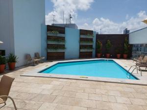 a swimming pool on the side of a building at Tambaú Flat, Mar Azul in João Pessoa