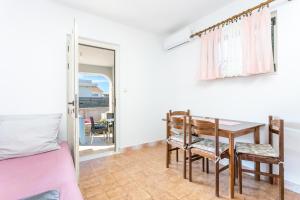 a bedroom with a bed and a table and a dining room at Apartments by the sea Sevid, Trogir - 4287 in Sevid