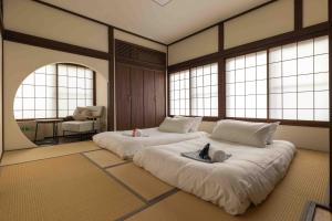 a room with two beds in a room with windows at Himecho@Yasushi in Nozawa Onsen