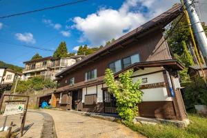 una casa con un poste delante de ella en Himecho@Yasushi en Nozawa Onsen