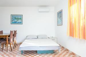 Schlafzimmer mit einem Bett und einem Esstisch in der Unterkunft Apartment Sevid 4287d in Sevid
