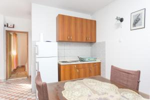 Apartment Sevid 4287d في سيفيد: مطبخ مع طاولة وثلاجة بيضاء