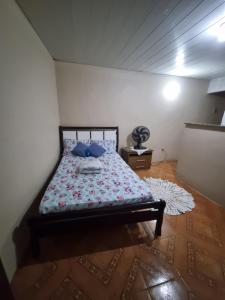 a bedroom with a bed with blue pillows on it at Kitnet em ambiente familiar in São Pedro da Aldeia