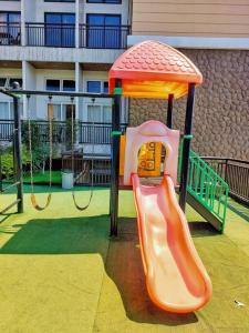 a small playground with a slide in a playground at Evergreen Suites Cozy Baguio Loft Retreat in Baguio