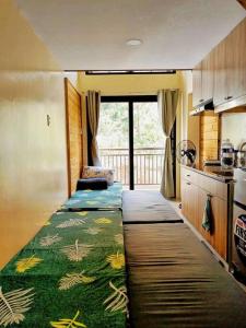 um pequeno quarto com duas camas numa cozinha em Evergreen Suites Cozy Baguio Loft Retreat em Baguio