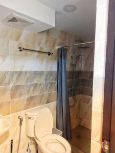 y baño con aseo y ducha. en Evergreen Suites Cozy Baguio Loft Retreat en Baguio