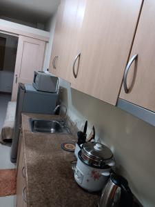 a kitchen with a sink and a stove with a pot at October Homes, Field Residences, Sucat, Parañaque, Airport Express in Manila